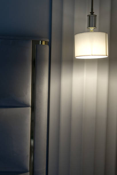 istock sconce hanging from the ceiling next to the bed in a hotel room 1900102219