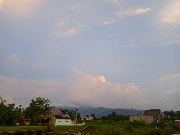 istock wide view of several houses, rice fields and mountains in the background 1900148183