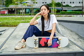 female Skateboarder girl sitting on ground