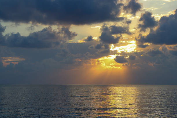 Bright beautiful Sunrise or Sunset at Sea. Bright sunset with a big sun under the Sea surface. Inspirational calm sea with sunset Sky. Ocean and Sky background. Colorful horizon over the water.