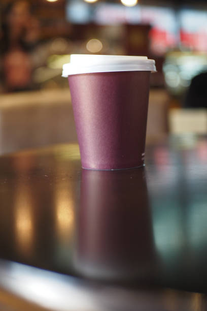 istock red color Blank take away kraft coffee cup on table , 1900159442