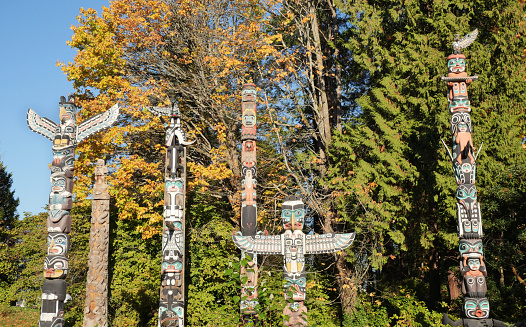 Stanley Park totem pole with autumn leaves, Vancouver, British Columbia, Canada.