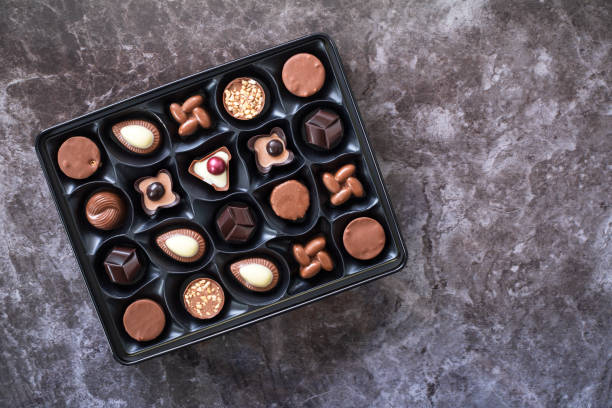 istock Box with delicious chocolate candies on gray marble background 1900209656