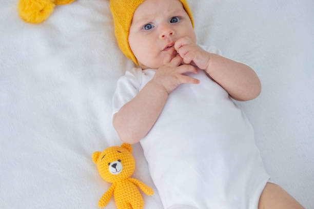 istock the child lies on a white background with a small bear 1900211707