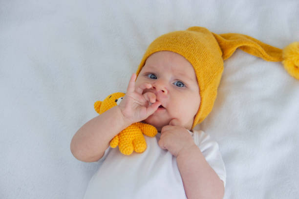 istock the child lies on a white background with a small bear 1900211709