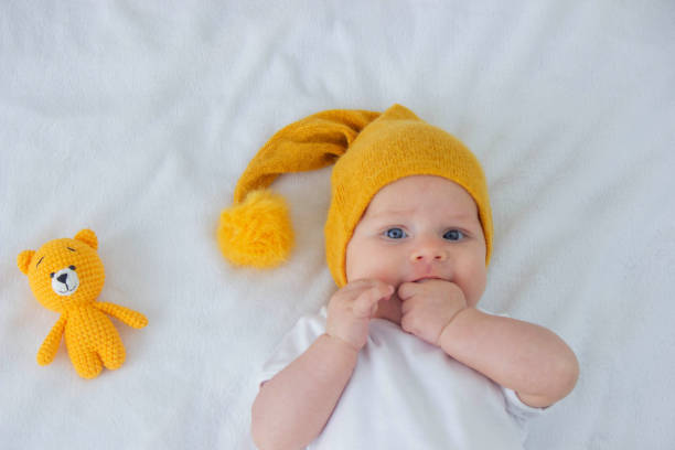 istock the child lies on a white background with a small bear 1900211712