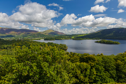 Ennerdale Lake, Cumbria in the Lake District with overcast storm clouds over the fells and the sun breaking through in the foreground