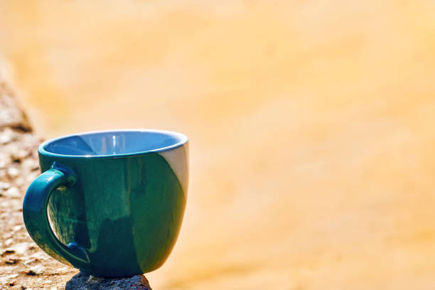 istock Green ceramic cup.Coffee, tea, beverages on the yellow beach sand 1900265646