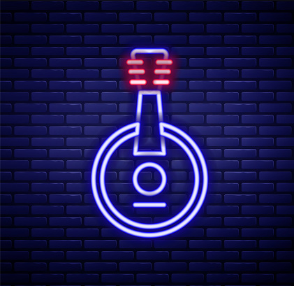 Glowing neon line Banjo icon isolated on brick wall background. Musical instrument. Colorful outline concept. Vector.