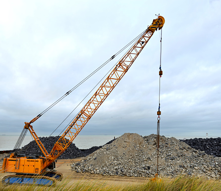 Blankenberge, West-Flanders, Belgium - December 30, 2023: high angle side view stationary Liebherr HS 885 HD crawler in front of recycled heap of concrete and stone material