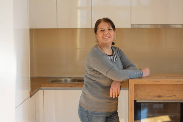 istock Mature woman at home smiling in the kitchen 1900378574