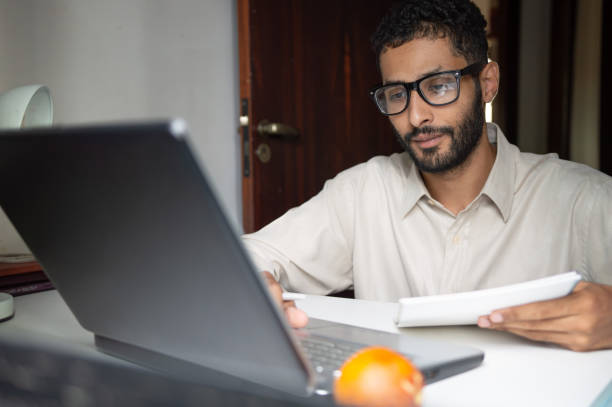 istock young black man studying for exams during the day at study table at home 1900387296