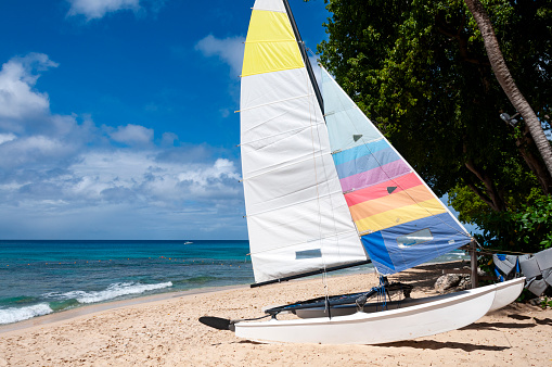 A hobby sailboat on the shore of a beach in Barbados