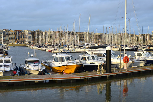 Blankenberge, West-Flanders, Belgium - December 30, 2023: sailing ships, motorboats and fisher ships moored in marina Blankenberge seen from a surrounding walking path on a sunny moment