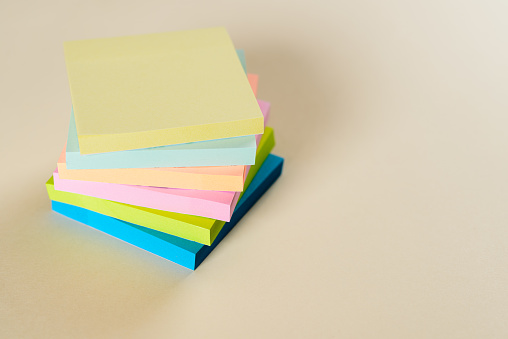Colorful page markers stacked on a beige background.