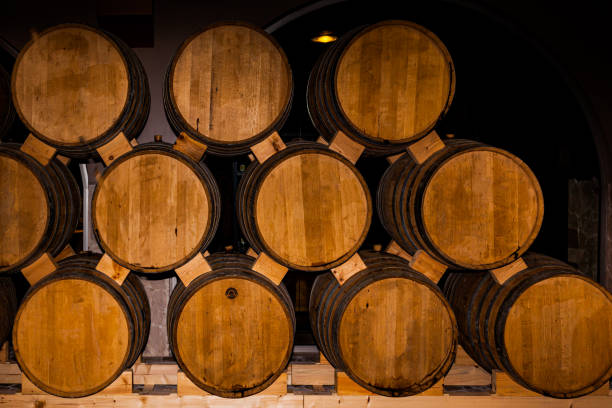 wine or brandy barrels at a winery. stacks of wine or brandy barrels. an old whiskey barrel. an old single malt whisky. - wine barrel cellar sherry stock-fotos und bilder