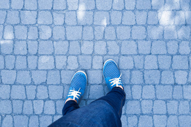 istock View from above on feet in moccasins on blue paving slabs background. 1900490443