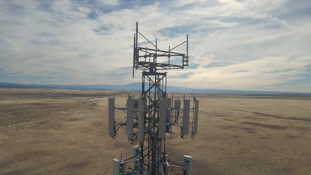 Closeup aerial view around of the telecommunications tower. On the top of a telecom tower installed antennas and transmitter wich transmits the signals of lte 5g 4g networks and mobile gsm operators.