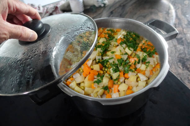 istock Assorted vegetables cut into small portions being stewed in a pot 1900566880