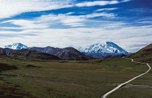 Distant view of remote road, through the tundra, leading to Mount Denali in the background.

Taken in Denali National Park, Alaska, USA