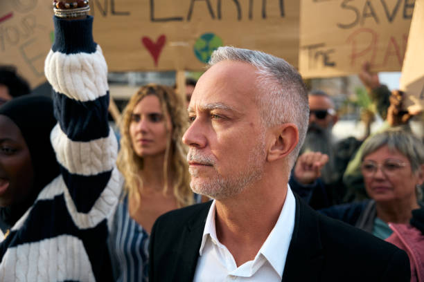 istock Angry and rebellious man and protesting with megaphone at demonstration at climate change 1900613712