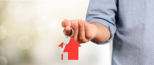 istock Real estate agent handing over  house keys in hand 1900672742