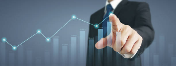 istock Businessman with chart financial symbols coming from hand 1900672747