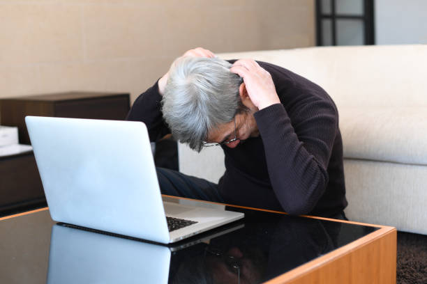 istock An older Asian man with gray hair is having trouble operating a laptop computer. 1900692025