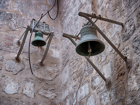 Two bronze bells hang from the walls inside the historic Chapel of St. John the Evangelist in the Old City of Jerusalem.