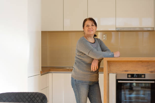 istock Mature woman at home smiling in the kitchen 1900724984