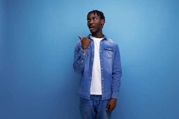 istock smart stylish american young man with dreadlocks points finger to the side 1900756731