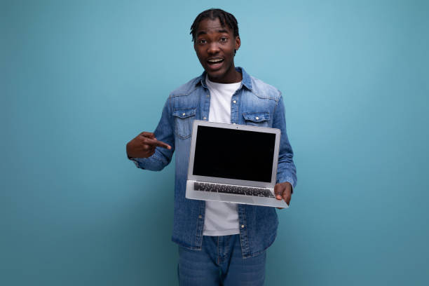 istock energetic american man with dreadlocks in denim jacket showing laptop screen with mockup 1900756742