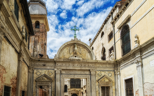 Casco antiguo de Venecia con águila y cruz de la Scuola Grande di San Giovanni Evangelista con torre de iglesia photo