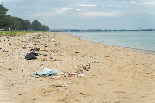 The sad image of a once-clean beach looking messy and dirty caused by plastic pollution from human activity. Pollution of beach and sea supporting the legislation action from the government for protecting the environment.