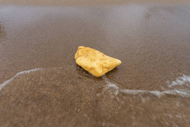 istock Yellow plastic foam abandoned on a seashore at the tourist attraction place. Improper waste disposal leading to the legislation action to protect the environment. 1900868279