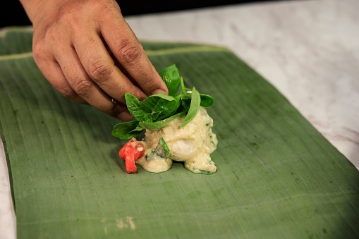 ASian Woman Cooking in the Kitchen, Step by Step Making Pepes (Steam Side Dish) from Indonesia. Add Lemon Basil Before Wrapping pepes with Banana Leaf