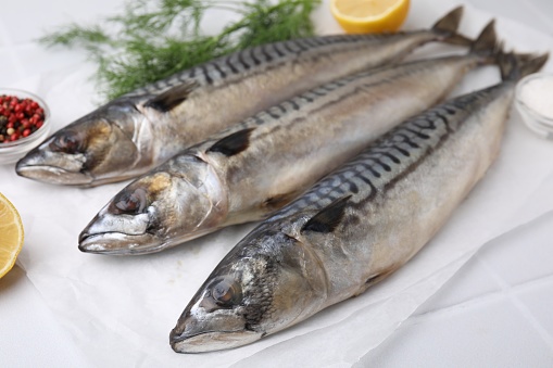 Tasty salted mackerels on white table, closeup