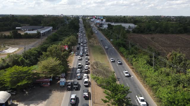 Bird's eye view of Traffic jams on the highway during the New Year Festival 1 JANUARY 2024,Nangrong Buriram,Thailand from the drone.