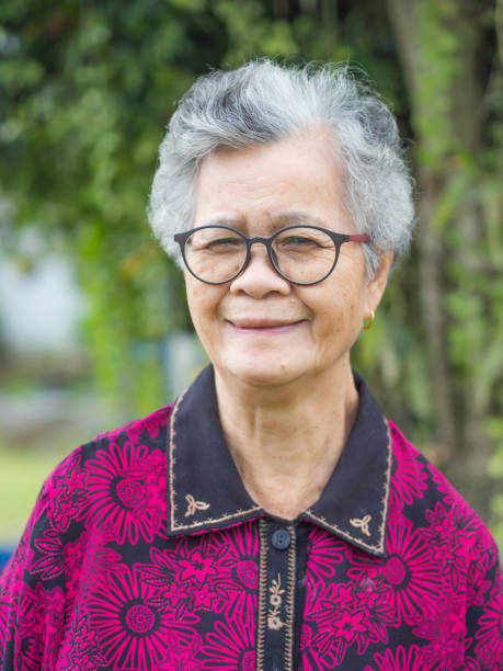 istock Senior Asian woman looking at camera while standing in a garden 1901080434