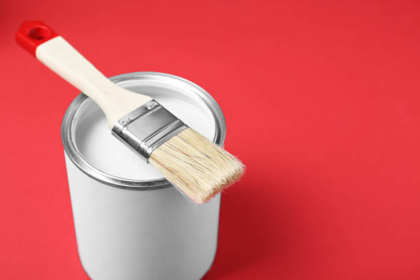 istock Can of white paint with brush on red background. Space for text 1901091189