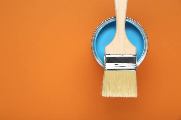 istock Can of light blue paint with brush on pale orange background, top view. Space for text 1901092214