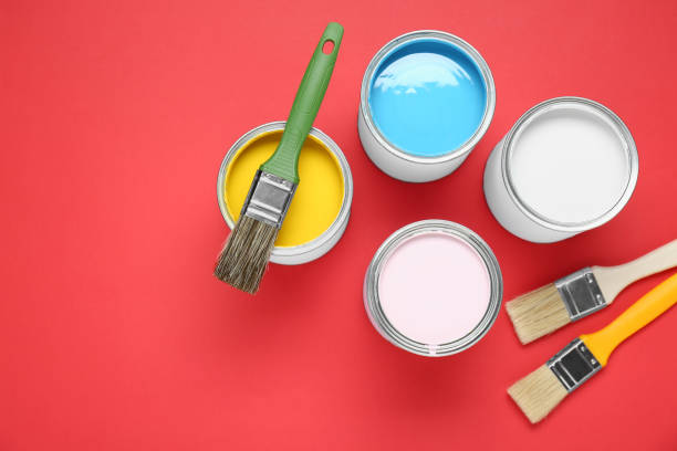 istock Cans of colorful paints and brushes on red background, flat lay. Space for text 1901093236