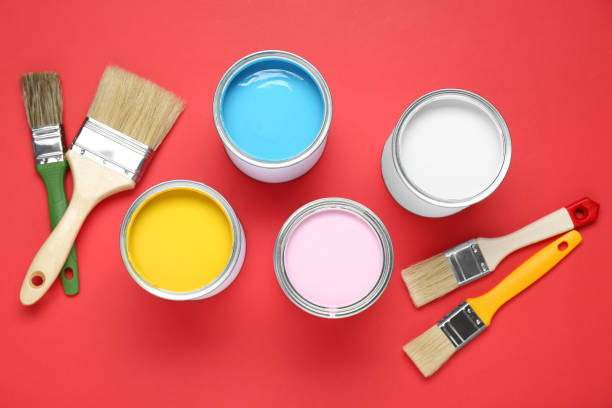 istock Cans of colorful paints and brushes on red background, flat lay 1901093241