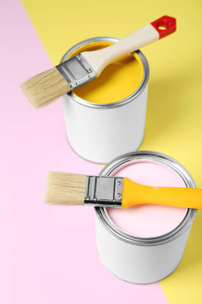 istock Cans of colorful paints with brushes on color background 1901093253