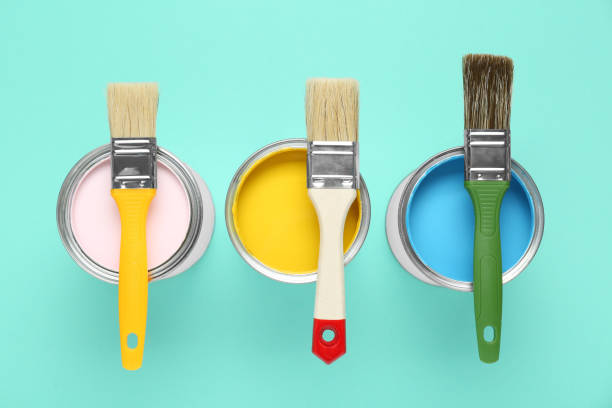 istock Cans of paints with brushes on turquoise background, flat lay 1901093771