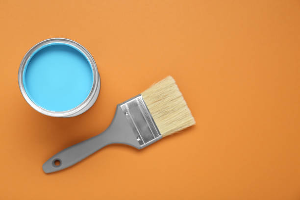 istock Can of light blue paint and brush on pale orange background, flat lay. Space for text 1901094285