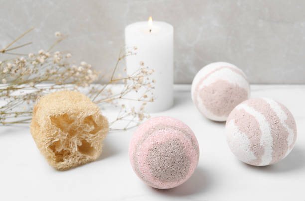 istock Bath bombs, loofah sponge and burning candle on white table 1901105150