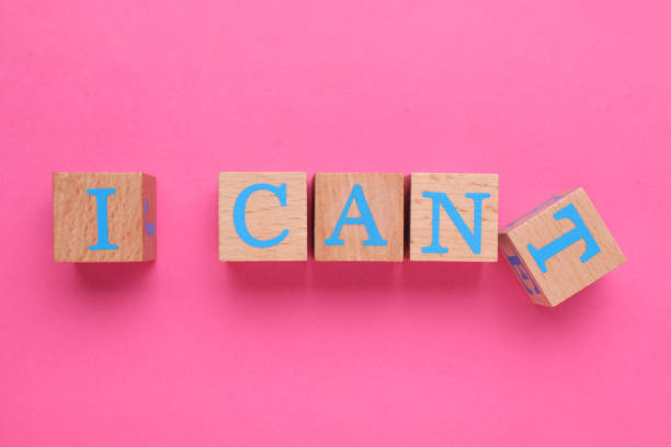 istock Motivation concept. Changing phrase from I Can't into I Can by removing wooden cube with letter T on pink background, top view 1901124110