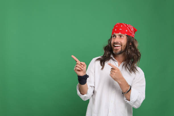 istock Hippie man pointing at something on green background, space for text 1901183745