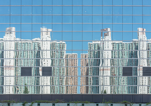 Reflection of high rise residential building of public estate on modern architecture in Hong Kong city